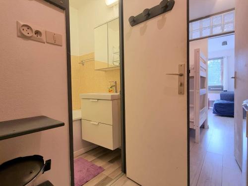 une pièce avec une porte donnant sur une cuisine avec un évier dans l'établissement Studio Cabine pour 4 à SuperDévoluy, proche pistes et commerces, wifi et parking gratuits - FR-1-525-209, à Saint-Étienne-en-Dévoluy