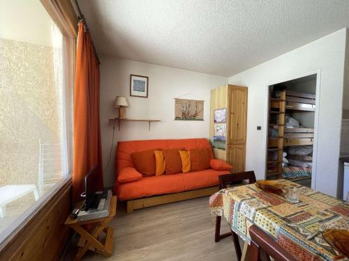 ein Wohnzimmer mit einem orangenen Sofa in einem Zimmer in der Unterkunft Appartement Montgenèvre, 1 pièce, 3 personnes - FR-1-330D-35 in Montgenèvre