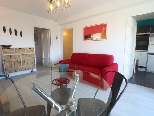 un salon avec un canapé rouge et une table en verre dans l'établissement Appartement T2 à Bénodet, refait à neuf, balcon, plage à pied, parking, classé 2 étoiles - FR-1-481-64, à Bénodet