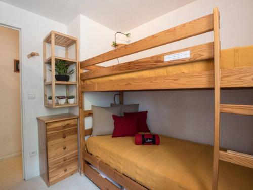 - une chambre avec 2 lits superposés et une valise rouge dans l'établissement Appartement T3 pour 6 à Saint Lary Soulan avec balcon et parking privé - FR-1-296-315, à Saint-Lary-Soulan