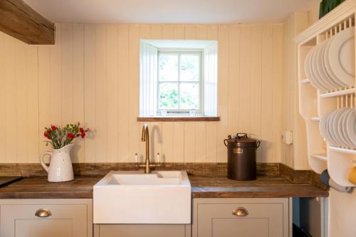 a kitchen with a sink and a window at Finest Retreats - Islip Mill House - Beautiful Riverside Home in Islip