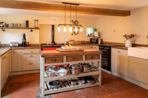 a kitchen with a island with pots and pans at Finest Retreats - Islip Mill House - Beautiful Riverside Home in Islip