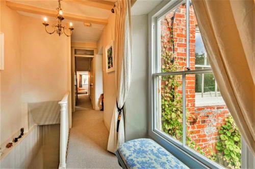 a hallway with a large window in a house at Finest Retreats - Islip Mill House - Beautiful Riverside Home in Islip