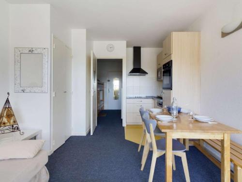 Il comprend une cuisine et une salle à manger avec une table et des chaises en bois. dans l'établissement Studio Gourette, 1 pièce, 6 personnes - FR-1-400-96, à Eaux-Bonnes