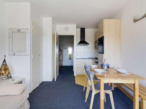 une cuisine et une salle à manger avec une table et des chaises en bois dans l'établissement Studio rénové pour 6 pers. au pied des pistes - FR-1-400-96, à Eaux-Bonnes