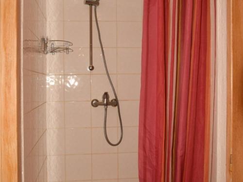 La salle de bains est pourvue d'une douche avec rideau de douche rouge. dans l'établissement Studio cosy au pied des pistes, Montgenèvre - 2 pers, animaux acceptés, WiFi, casier à skis - FR-1-266-153, à Montgenèvre