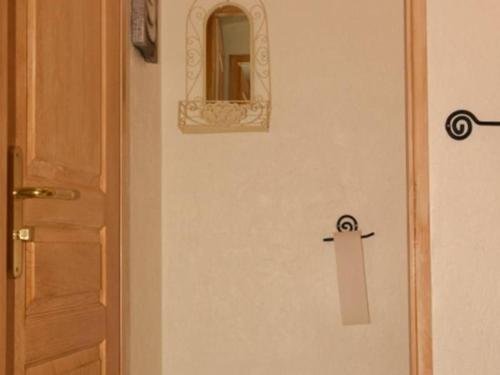 une porte munie d'une pancarte à côté d'un miroir dans l'établissement Studio cosy au pied des pistes, Montgenèvre - 2 pers, animaux acceptés, WiFi, casier à skis - FR-1-266-153, à Montgenèvre