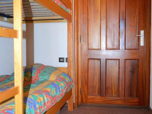 - une chambre avec des lits superposés et une porte en bois dans l'établissement Joli studio cabine 4 pers, balcon, PKG, Bolquère-Pyrénées 2000 - FR-1-592-14, à Bolquère-Pyrénées 2000