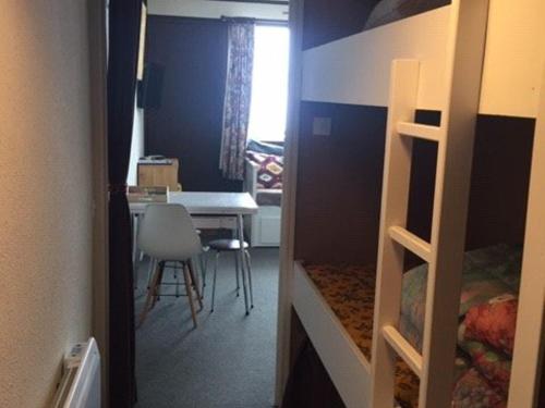 - une chambre avec des lits superposés et une table avec une chaise dans l'établissement Studio confortable pour 4 avec ascenseur et balcon à Arette - FR-1-602-96, à Arette
