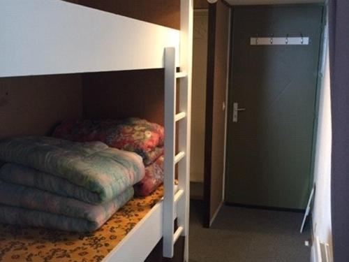 Cette chambre comprend des lits superposés et une porte menant à une chambre. dans l'établissement Studio confortable pour 4 avec ascenseur et balcon à Arette - FR-1-602-96, à Arette