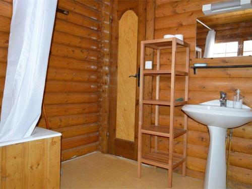 La salle de bains est pourvue d'un lavabo et d'un mur en bois. dans l'établissement Chalet en Pierre avec Cheminée, 3 Chambres & Balcon, WIFI, Bolquère - 7 pers - FR-1-592-26, à Bolquère-Pyrénées 2000