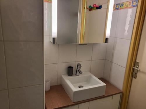 une salle de bain avec un lavabo blanc et un miroir dans l'établissement Appartement lumineux 6 pers, pied des pistes, balcon sud, ascenseur, proche commerces, Palais des Sports - FR-1-262-176, à Orcières