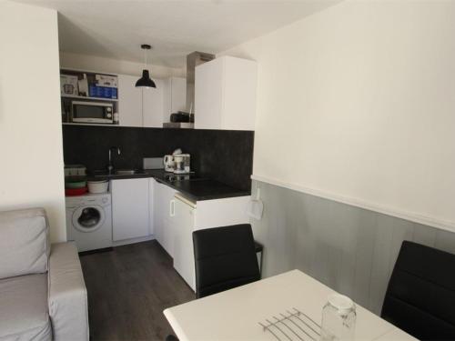Il comprend une cuisine et un salon avec une table. dans l'établissement Appartement 2 Pièces avec Cabine, Parking, Internet - Bagnères-de-Luchon - FR-1-313-159, à Luchon