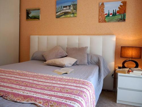 - une chambre avec un lit et un livre dans l'établissement Appartement 4 pers. à Luchon - Balcons Sud, Parking et Proximité Thermes et Commerces - FR-1-313-151, à Luchon