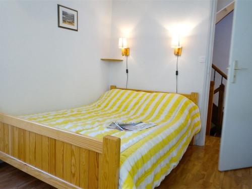 a bedroom with a yellow and white bed with two lights at Maison Bagnères-de-Luchon, 4 pièces, 6 personnes - FR-1-313-158 in Luchon