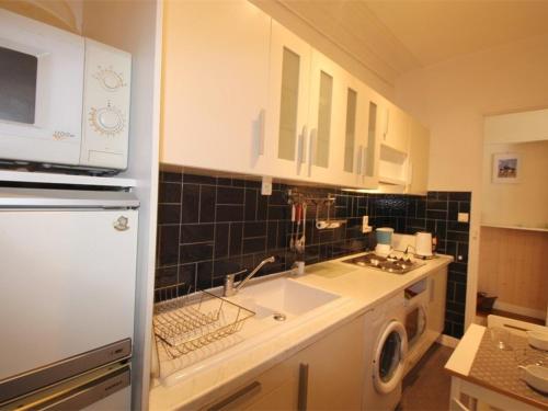 une cuisine avec un réfrigérateur blanc et un évier dans l'établissement Studio au centre avec ascenseur et animaux admis - FR-1-313-163, à Luchon