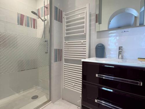 une salle de bain avec douche et lavabo dans l'établissement Charmant T1 bis avec terrasse et parking, à 1km des thermes, idéal pour 2 pers, Wi-Fi, Cambo-les-Bains - FR-1-495-90, à Cambo-les-Bains