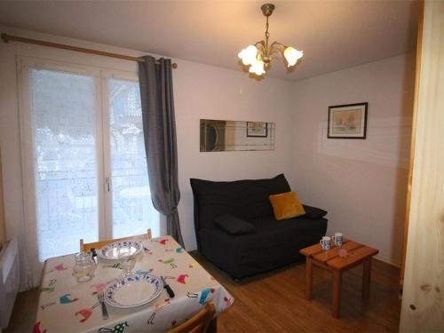 a living room with a table and a couch at Studio Bagnères-de-Luchon, 1 pièce, 4 personnes - FR-1-313-193 in Luchon