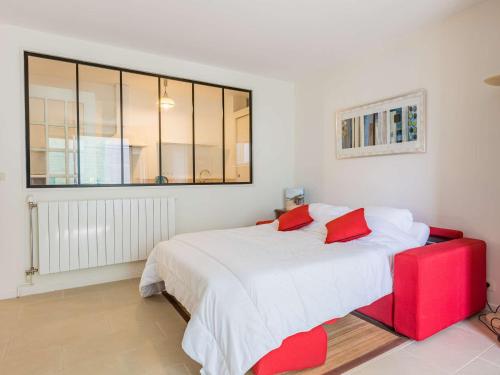 - une chambre avec un grand lit blanc et des oreillers rouges dans l'établissement Studio Saint-Jean-de-Luz, 1 pièce, 2 personnes - FR-1-4-596, à Saint-Jean-de-Luz