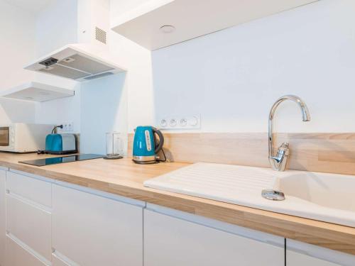 uma cozinha com armários brancos e um lavatório em Studio Saint-Jean-de-Luz, 1 pièce, 2 personnes - FR-1-4-596 em Saint-Jean-de-Luz