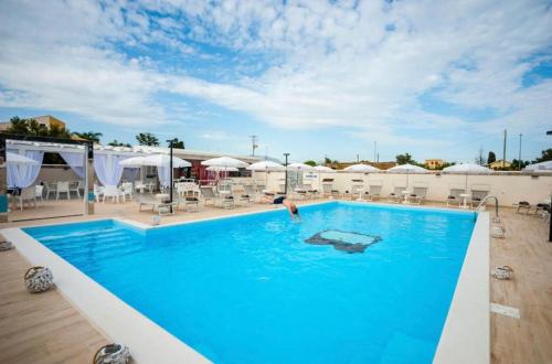 una persona in una piscina di un hotel di Bono Vacanze Villa San Marco Luxury Holidays Homes & Hotel a Sciacca