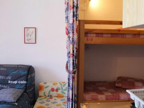 - un lit superposé et un canapé dans une chambre dans l'établissement Studio calme pour 4 pers. à Risoul, proche pistes, animaux admis, parking gratuit - FR-1-330-512, à Risoul