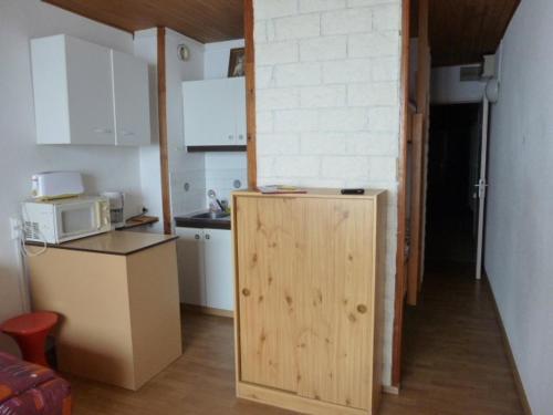 une petite cuisine avec un réfrigérateur et un micro-ondes dans l'établissement Studio au pied des pistes avec parking et casier à skis, Arette - FR-1-602-9, à Arette