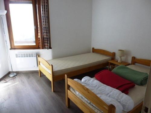 Cette petite chambre comprend 2 lits et une fenêtre. dans l'établissement Appartement Arette, 2 pièces, 6 personnes - FR-1-602-28, à Arette