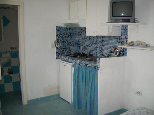 a kitchen with a stove and a tv on top at Casadelpino Residence La Piana in Ponza