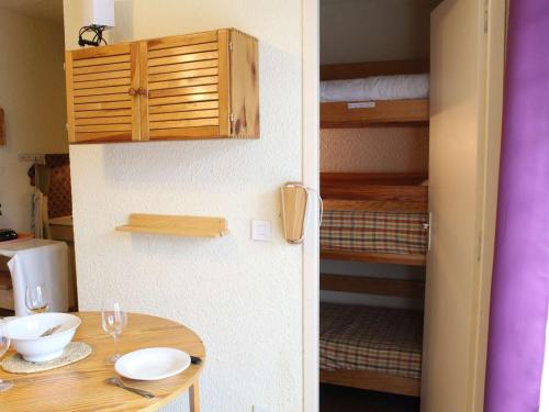 Il comprend une cuisine avec une table et une chambre avec des lits superposés. dans l'établissement Studio cabine avec accès direct aux pistes, balcon, et piscine - 4 couchages, Risoul 1850 - FR-1-330-518, à Risoul
