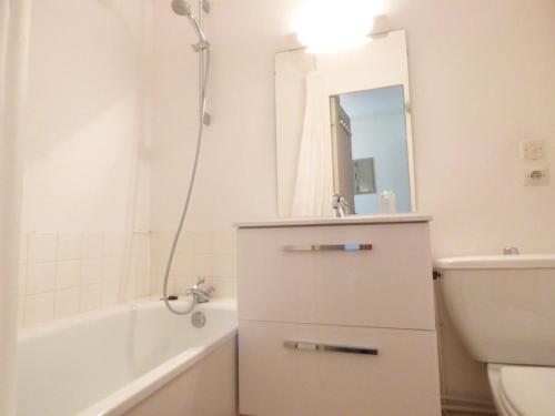 a bathroom with a sink and a tub and a toilet at Studio Arette, 1 pièce, 5 personnes - FR-1-602-67 in Arette