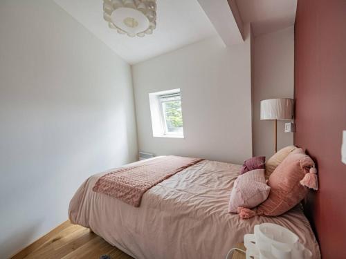 a bedroom with a bed with pink walls and a window at Bénodet : Appartement rénové face mer, 100m de la plage, parking privé, balcon, 3 étoiles, 4 pers. - FR-1-481-80 in Bénodet