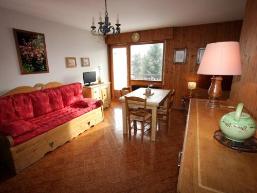 a living room with a red couch and a table at Studio Le Grand-Bornand, 1 pièce, 4 personnes - FR-1-458-89 in Le Grand-Bornand