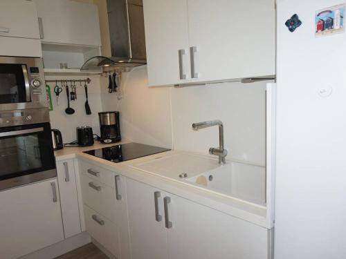une cuisine avec des armoires blanches et un évier dans l'établissement Appartement à Cabourg proche plage et casino, 4 personnes, parking privatif - FR-1-465-61, à Cabourg