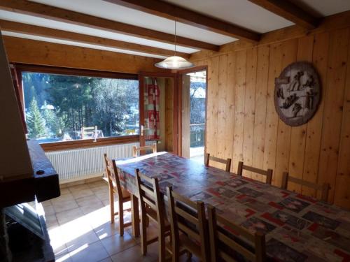 une salle à manger avec une table et des chaises et une fenêtre dans l'établissement Grand T5 lumineux pour 11 pers. - balcon, cheminée, garage au Grand-Bornand - FR-1-458-137, au Grand-Bornand