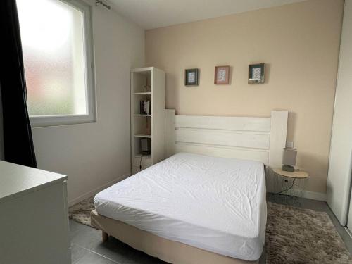 um quarto com uma cama branca e uma janela em Appartement Cambo-les-Bains, 2 pièces, 2 personnes - FR-1-495-94 em Cambo-les-Bains