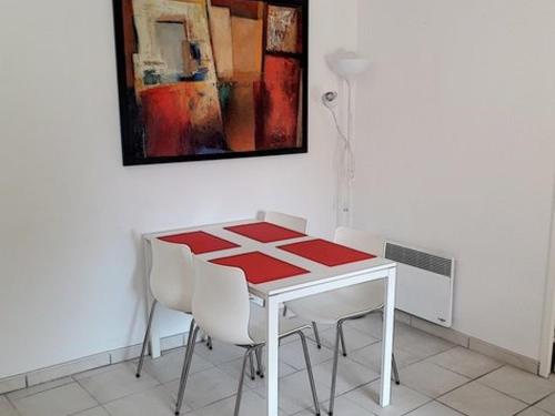 une table et des chaises dans une pièce avec un tableau dans l'établissement T2 avec Grande Loggia, Parking, Proche Plage et Commerces à La Favière - FR-1-610-68, à Bormes-les-Mimosas