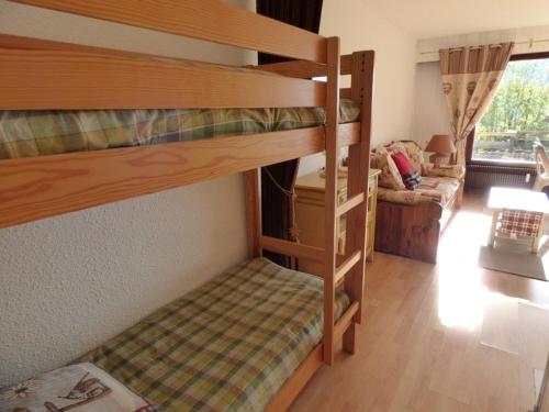 a room with two bunk beds and a couch at Studio Le Grand-Bornand, 1 pièce, 4 personnes - FR-1-458-122 in Le Grand-Bornand