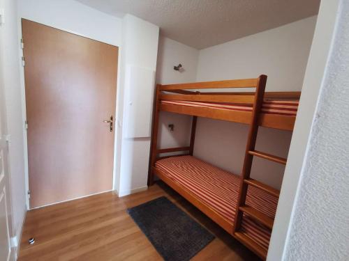 Cette petite chambre comprend 2 lits superposés et une porte. dans l'établissement Studio cabine 4 pers - Terrasse, Piscine, Fitness, Parking - Proche pistes - FR-1-404-268, à La Mongie
