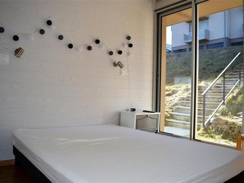 een slaapkamer met een wit bed en een groot raam bij Appartement Les Angles, 2 pièces, 4 personnes - FR-1-593-33 in Les Angles