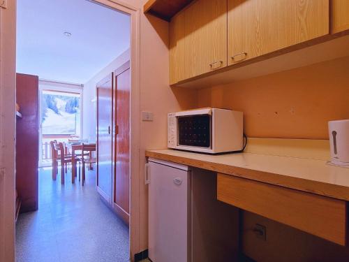 une cuisine avec un four micro-ondes sur un comptoir et une table dans l'établissement Studio au pied des pistes avec Wifi, parking, animaux admis - FR-1-525-186, à Saint-Étienne-en-Dévoluy