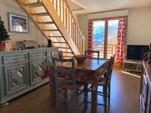 une cuisine avec une table et des chaises ainsi qu'un escalier dans l'établissement Appartement T2 confortable, 4 pers., garage, WIFI, Barèges, proche thermes et ski-bus - FR-1-403-97, à Barèges