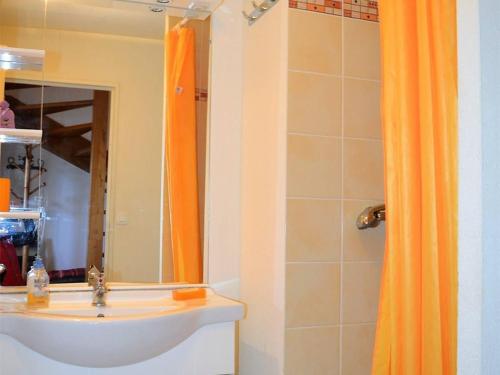 La salle de bains est pourvue d'un rideau de douche orange et d'un lavabo. dans l'établissement Appartement T4 aux Angles avec Balcon et Parking - FR-1-593-2, aux Angles