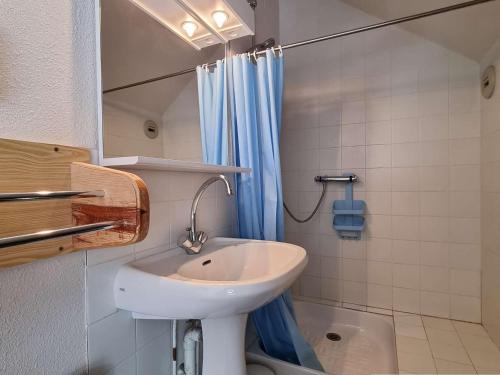 a bathroom with a sink and a blue shower curtain at Appartement Le Dévoluy, 2 pièces, 6 personnes - FR-1-525-178 in Le Dévoluy