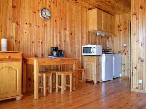 - une cuisine avec des murs en bois et du parquet dans une cabine dans l'établissement Bas de chalet cosy avec balcon et 1 chambre - FR-1-593-26, aux Angles