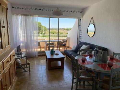 un salon avec un canapé et une table dans l'établissement Appartement 2 pièces avec parking à Port Camargue - FR-1-250-170, au Grau-du-Roi