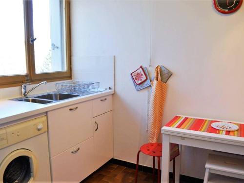 une cuisine avec un évier et une machine à laver dans l'établissement Appartement 2 pièces avec piscine et parking à 2 pas de la plage au Lavandou - FR-1-251-384, au Lavandou