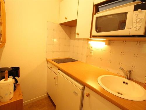 une cuisine avec un évier et un micro-ondes dans l'établissement Luchon: Appart 2 pièces cabine - Balcon, Parking - FR-1-313-166, à Luchon