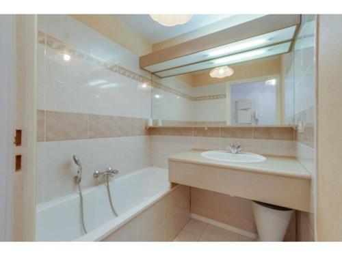 une salle de bain avec un lavabo, une baignoire et un miroir dans l'établissement Appartement Studio Cabine à Fréjus, Piscine, Plage à 500m, Clim, Parking, Terrasse, 4 Couchages - FR-1-226A-110, à Fréjus