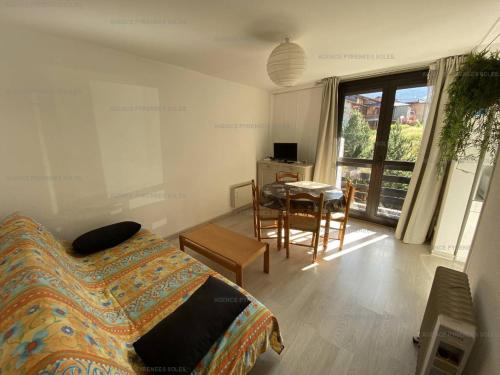 1 dormitorio con mesa, cama, mesa y sillas en Appartement Les Angles, 3 pièces, 6 personnes - FR-1-295-154, en Les Angles